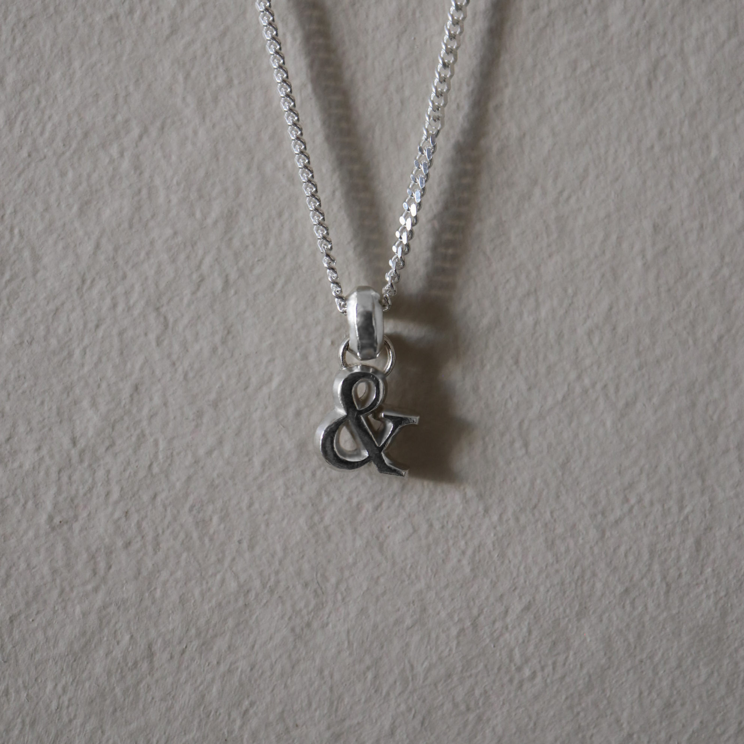 Symbol pendant with bail on curb chain